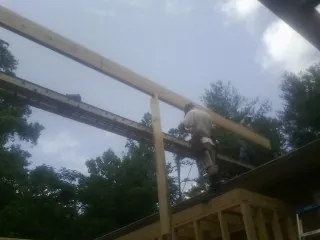 Carpenter setting a ridge beam over a new addition frame — Ice Dam Removal by Roofing Brothers in Short Hills