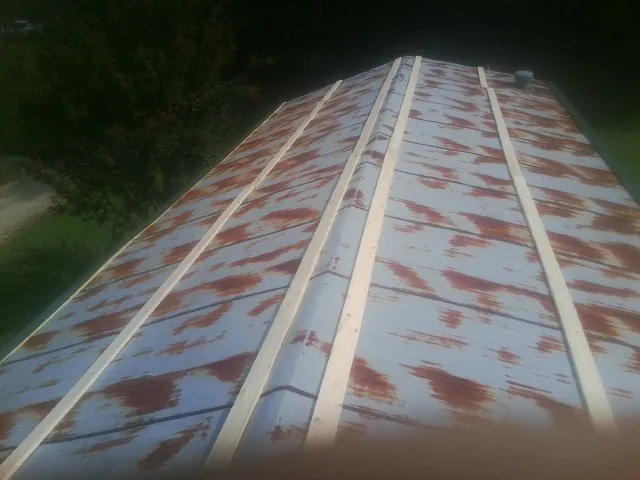 Rusted metal roof panels with new wood purlins before replacement — Storm Damage Roof Repair in Short Hills by Roofing Brothers