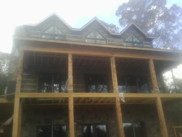 Dormers and porch framing on a large log home under construction — Roof Coating work by our crew in Short Hills