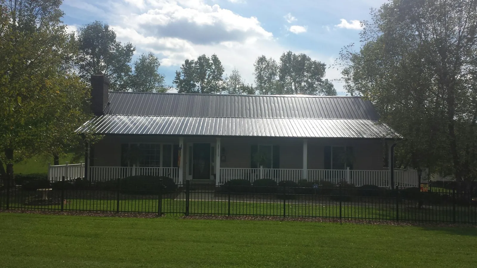 Gray metal roof on a brick ranch with a full width front porch — Gutter Guard Installation work by our crew in Short Hills