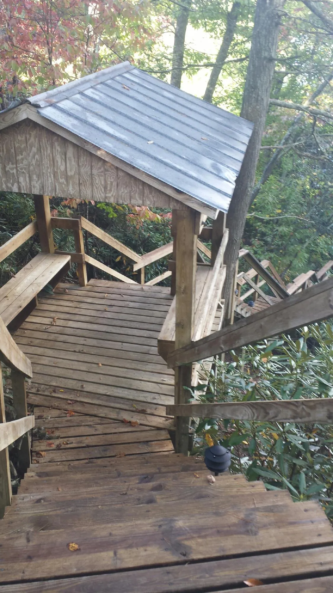 Metal roofed shelter over wooden steps on a wooded walkway — Skylight Repair & Installation work by our crew in Short Hills